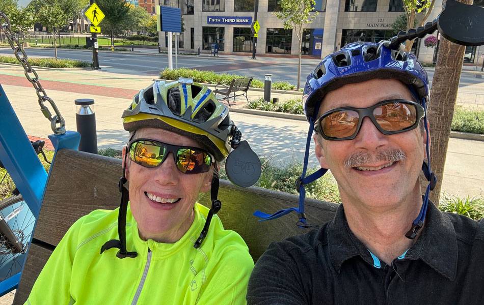 ruth and don smiling in their biking gear and  helmets